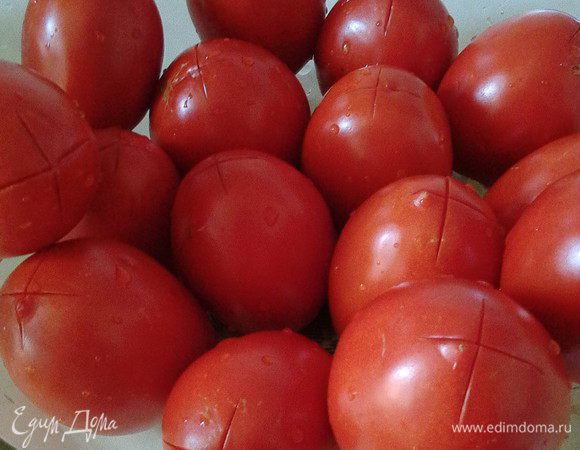 Для этого рецепта подходят помидоры сорта сливка- плотные, продолговатые, спелые. Их следует помыть, сделать крестообразные надрезы на кожице и залить кипятком на 1-2 минуты. Затем остудить их холодной водой. Эта манипуляция позволит с лёгкостью избавиться от помидорной кожицы.