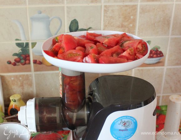 Нарежьте помидоры на четвертинки и положите в мясорубку, используя насадку для приготовления сока. 
