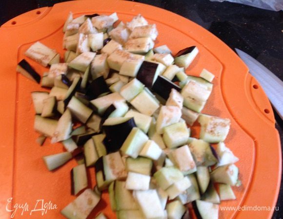 Баклажаны порежьте кубиками, посолите и оставьте на 10 минут, после чего промойте холодной водой и добавьте к луку.