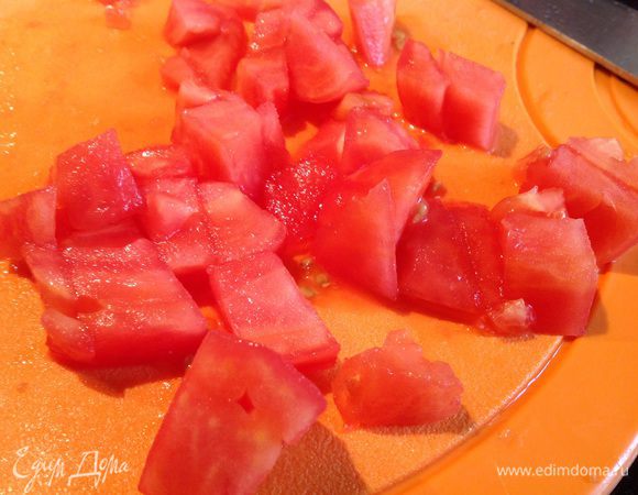 У помидоров снимите кожицу, нарежьте, и добавьте на сковороду, жарьте еще 2 минуты, потом выложите овощи.