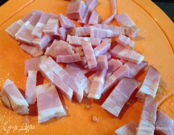 Бекон нарежьте тонкими полосками и жарьте на той же сковороде.