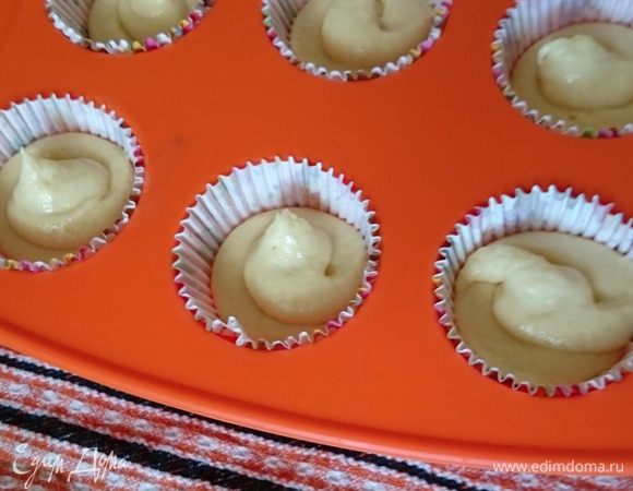 Выложите в форму бумажные корзинки. Используя кондитерский мешок заполните форму для маффинов наполовину.