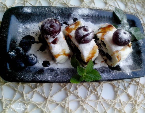 Перед подачей посыпать сахарной пудрой, украсить стручком ванили и листьями мяты. Посыпать ягодами.