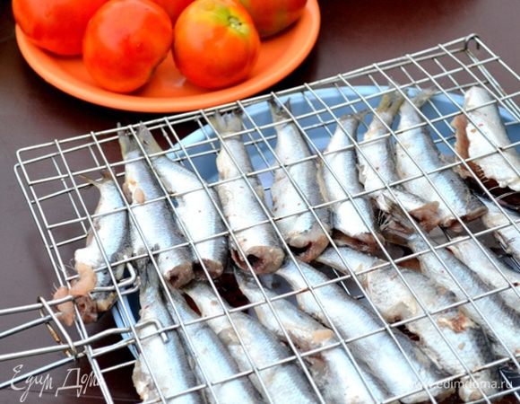 Укладываем рыбку на решетку. Плотно ее закрываем зажимами.