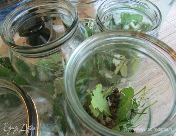 Тем временем на дно стерилизованных банок уложить специи (на ваш вкус, у меня - черный перец горошком, гвоздика, душистый перец, семена укропа), смородиновые и вишневые листья, лавровый лист, чеснок.
