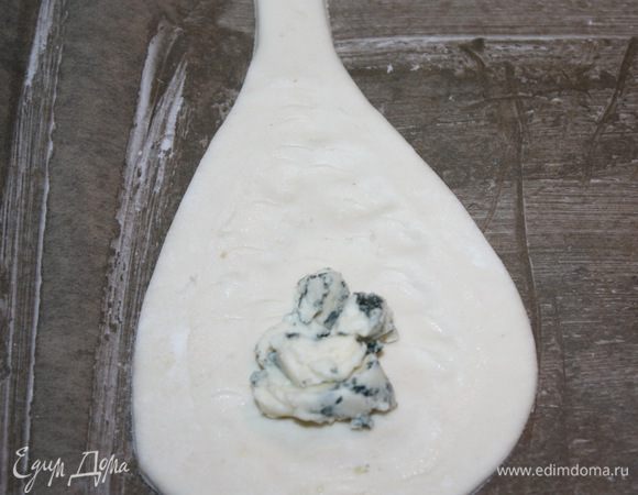 Тесто раскатываем, вырезаем форму груши и кладем тесто на пищевую бумагу, смазанную маслом. На каждый пласт теста кладем по одной чайной ложке сыра дор блю, предварительно размяв его. Сыр надо положить в ту область, где будет сердцевина груши. 