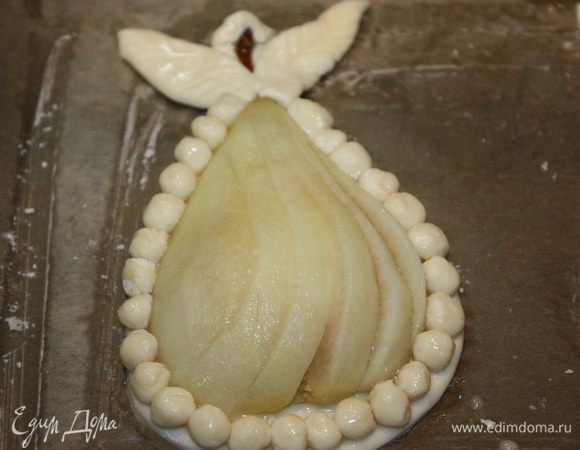 Каждую половинку груши надрезаем, не доходя до хвостика, и выкладываем на тесто с сыром. Делаем шарики из теста и листочки. Выкладываем шарики по периметру, а листочки около хвостика. Смазываем тесто слегка взбитым яйцом. Яйцо не должно попасть на груши. Груши смазываем сиропом, в котором варили груши, отправляем в духовку при температуре 180°C на 30-35 минут.