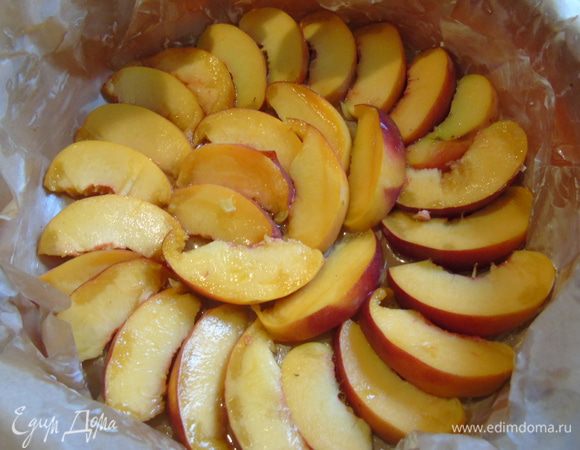 Нектарин (персики) нарезать дольками. Форму застелить пергаментом, вылить мед и выложить нектарин.