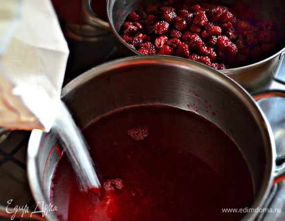 В полученный сок всыпьте сахар, аккуратно перемешайте, чтобы все крупинки растворились, и варите на среднем огне 20 мин с момента закипания. Затем аккуратно погрузите в сок ягоды малины. 