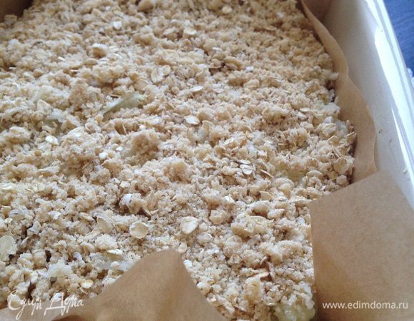 Поверх крошки выложить яблоки (можно присыпать корицей). Присыпать яблоки оставшейся крошкой.
Выпекать в предварительно разогретой духовке до 180°C 30-35 минут.