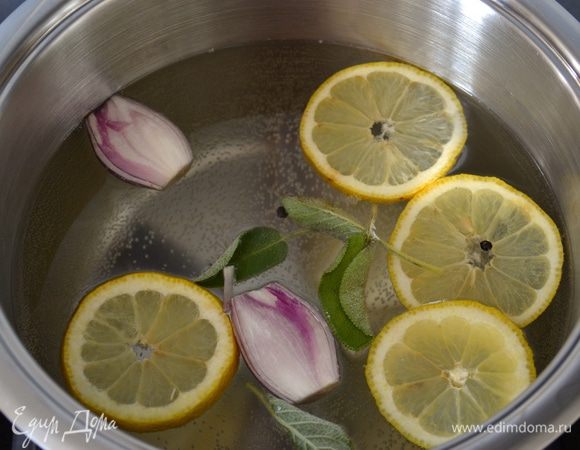 Первым делом отварить куриную грудку. Для этого поставить закипать кастрюлю с водой. Лимон как следует вымыть. Половину лимона нарезать дольками и положить в воду. Лук-шалот очистить и, разрезав пополам, также положить в кастрюлю с водой. Добавить листья шалфея, горошины черного перца и белое вино. Дать воде закипеть.