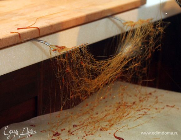 Делаем карамельную нить: 
Варим сахар, постоянно помешивая, до образования карамели. На поверхность, выложенную пекарской бумагой, разбрызгиваем немного схватившуюся карамель (она должна быть тягучей), горизонтальными движениями, для образования нитей (запутанные нити).