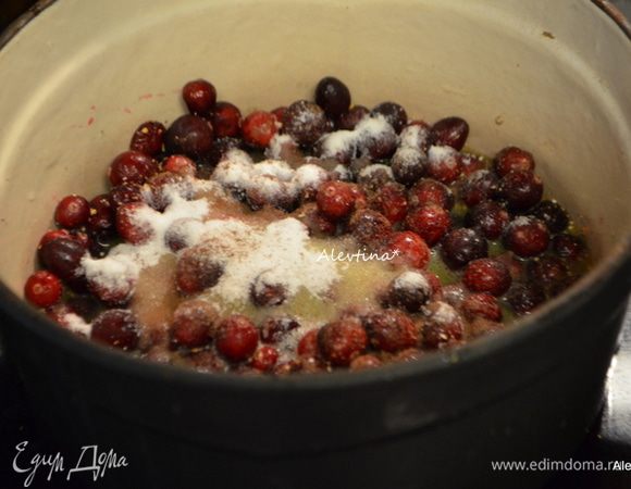 Выложить помытую клюкву в кастрюлю с тяжелым дном, добавить цедру, душистый горошек, сахар и апельсиновый сок. Для жидкого соуса можно добавить апельсинового сока.