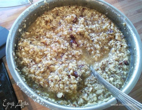 В ковшике растопите масло с сахаром и водой, добавьте ванильный сахар и цедру. Снимите с огня и вмешайте орехи. 