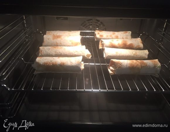 Выкладываем сырную смесь на лаваш и заворачиваем рулетики. Кладем их на решетку.