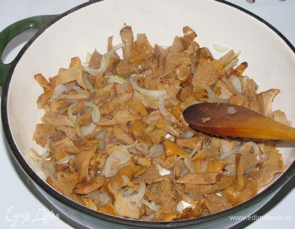 Луковицу нарезать тонкими полукольцами, обжарить до прозрачности на смеси оливкового и сливочного масла. Добавить лисички, жарить еще немного.