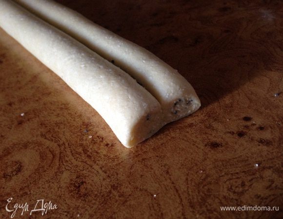 Определить середину и скрутить тесто с двух сторон в рулет.