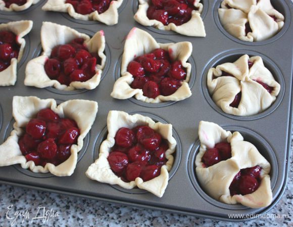 Всю вишню распределить по пирожкам. Противоположные уголки теста соединить в центре, крепко сжать.