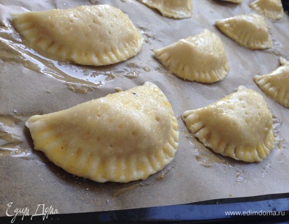 Пирожки переложить на противень застеленный бумагой для выпечки, смазать желтком и отправить в духовку на 20-25 минут при температуре 180 градусов.