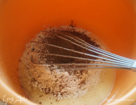 Сливочное масло растопить и влить в растертые яичные желтки. Добавить муку и какао-порошок, хорошо вымешать. Тесто получится достаточно густое.