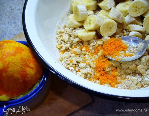 Бананы очистить (взять не очень крупные), порезать на толстые кружочки, добавить к тесту. 
Апельсин вымыть, натереть цедру, выжать сок.
Добавить в миску, перемешать.

