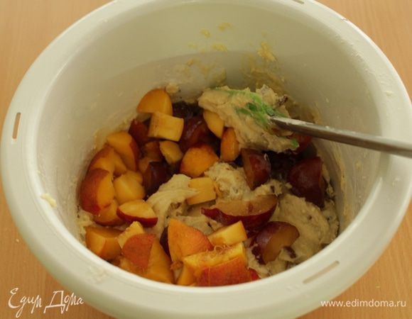 Отложите 4–5 слив в сторону. Остальные разрежьте пополам, удалите косточки и нарежьте кубиками. И добавьте в тесто.