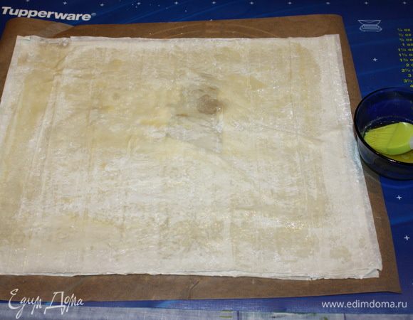 Оставшееся сливочное масло растопить. Пергамент смазываем маслом, Затем берем три листа теста фило, каждый лист смазываем маслом и кладем друг на друга. Использовать пищевую бумагу не обязательно. Но ее использование хорошо помогает доставать готовую пахлаву из формы, не повредив ее.