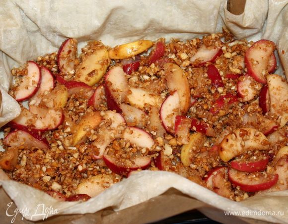 Выкладываем первые три слоя теста в форму и поднимаем края вверх. Далее кладем половину яблочной начинки.