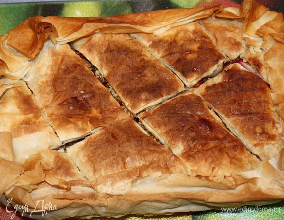 Готовую пахлаву достаем из духовки и выкладываем на ровную поверхность. Пергамент убираем.