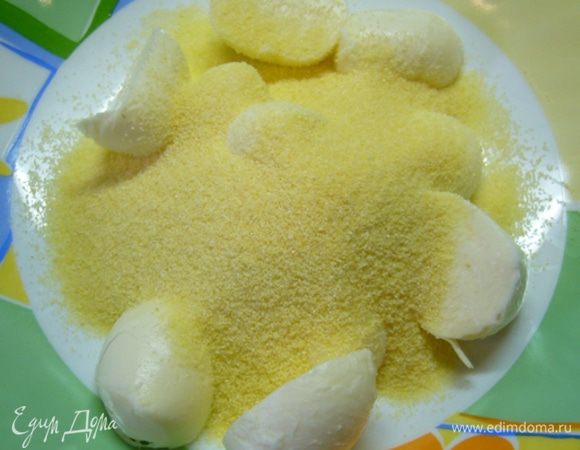 Разрезать каждый шарик пополам, обвалять в семолине.