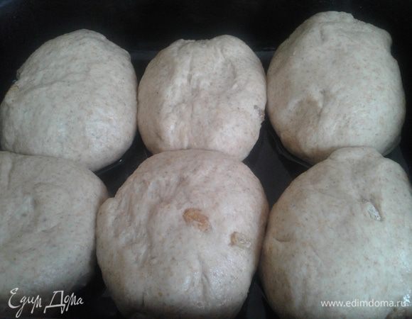 В подошедшее тесто добавить промытый и обсушенный (обвалять в муке) изюмчик и разделить тесто на 6 булочек. Сложить их в смазанную маслом форму, в которой будем выпекать и оставить на 20 минут (пока разогреть  духовку до 200 градусов). Расстоявшиеся саечки смазать молочком и посыпать цельнозерновой мукой.