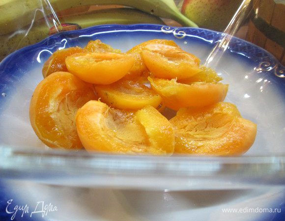 Разрезаем абрикосы на половинки, удаляя косточки. Складываем их в емкость для крюшона. Варим из сахара и воды сироп. Горячим сиропом заливаем  абрикосы.
