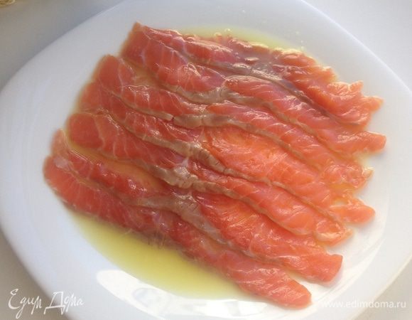 Нарезать форель тонкими слойками и разложить по тарелке с соком в один слой.