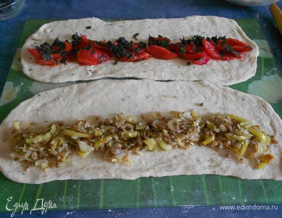 Раскатать тесто прямоугольником. На одну часть положить начинку из лука с перцем, на вторую — начинку из помидоров.