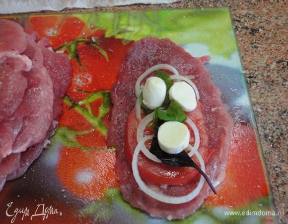 Баклажаны промыть водой и промокнуть бумажными полотенцами. На каждую отбивную выложить колечко помидора, лука, листья базилика и кусочек моцареллы.