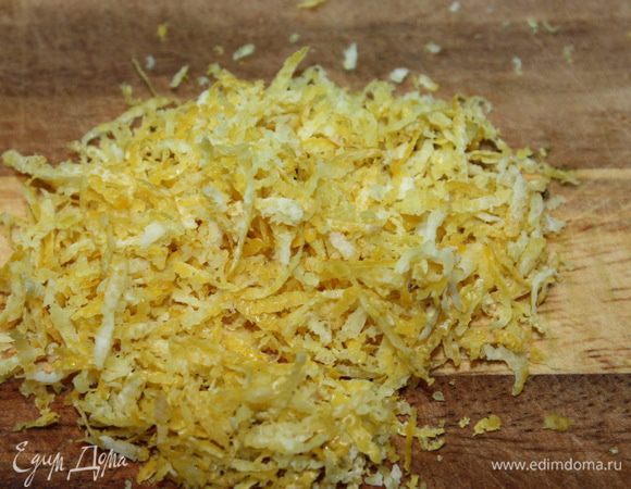 При помощи сырной терки снимаем цедру лимона.