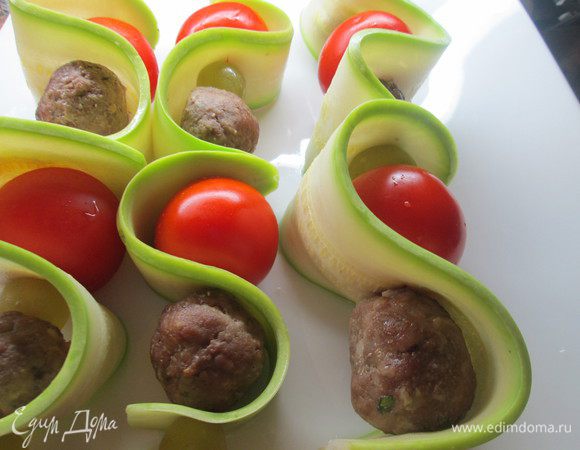 На шпажки нанизываем, чередуя обжаренные фрикадельки, виноград и черри, пропуская между ними ленточки цукини, смазываем наши шашлычки соусом и запекаем 15-20 минут при 180*С.