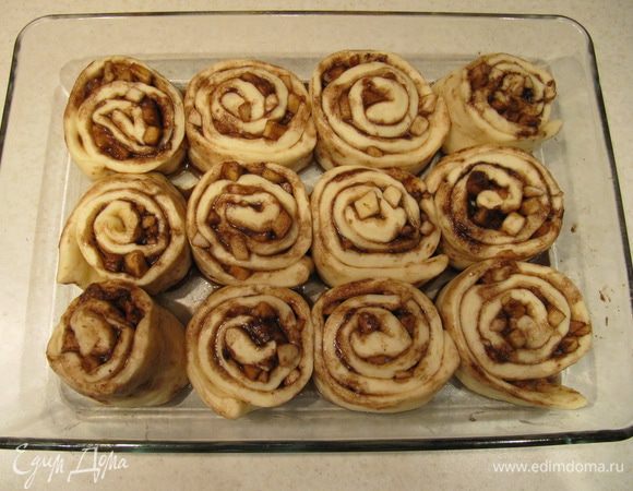 Синнабоны выложить в форму, смазанную небольшим количеством растительного масла. Накрыть пленкой и оставить на 20 минут.
Накрыть форму фольгой и отправить в духовку, предварительно разогретую до 190C, на 25 минут.
