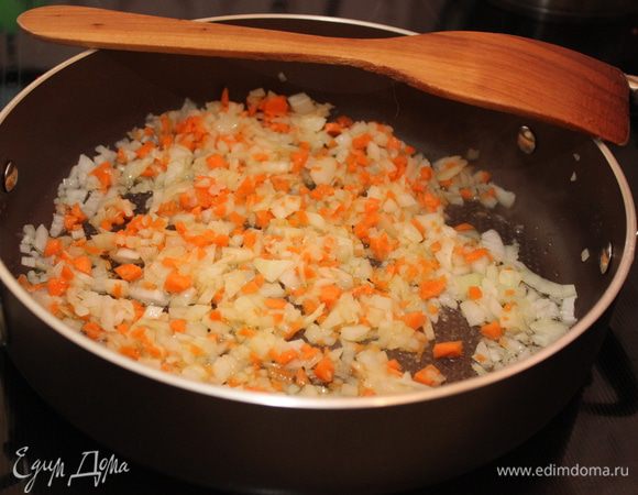 Сначала приготовим мясной соус. Для этого лук, чеснок и морковь почистите, мелко порубите, обжарьте на оливковом масле до мягкости.