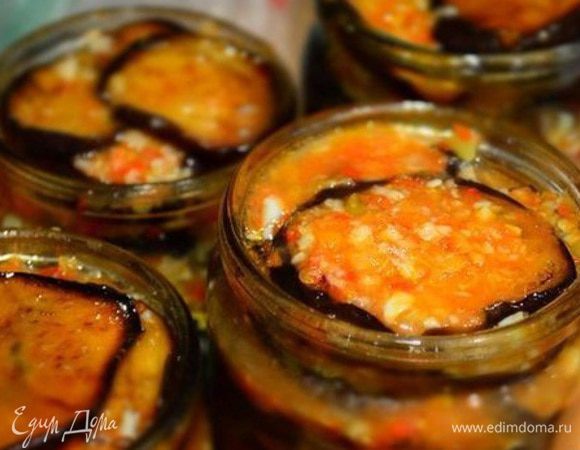 В чистые и простерилизованные банки складывать обжаренные баклажаны, каждый слой поливать соусом из  перекрученных овощей. Прикрыть железными  крышками. На дно кастрюли уложить полотенце, поставить банки и налить теплой воды по плечики. Довести до кипения и стерилизовать 10 минут.