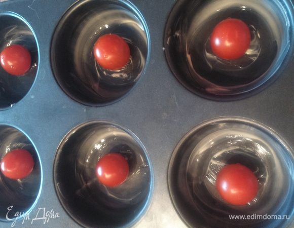 Формы для маффинов смазать маслом (сливочным либо другим). 
Выложить в формы смесь. 
Вложить в каждый маффин по одной помидорке черри.