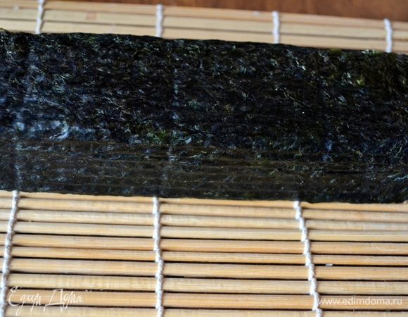 Аккуратно, не торопясь, сворачиваем с помощью циновки рулет. Секрета здесь целых три:
1. Не торопись!
2. Начинка должна оказаться внутри - мы ее "укутываем" слоем риса и нори
3. Очень плотно сжимаем, формируем такой брусок, который самостоятельно будет держать форму без циновки.