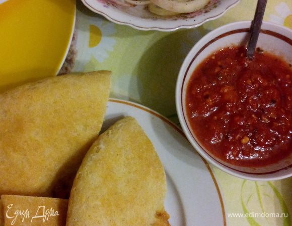 Готовим томатный соус. С большого мясистого помидора снимаем кожицу, измельчаем (на терке или в блендере), полученный сок варим в небольшой кастрюльке до густоты кетчупа или чуточку жиже.
За 5 минут до готовности добавляем все специи и пропущенный через чесночницу чеснок, еще немного прогреваем и все, вкуснейший соус к мясу готов!