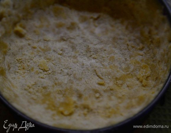 Форму смазать маслом (диаметр 20 см) и высыпать крошку, сформировать дно и бока, но при этом сильно не утрамбовывать.