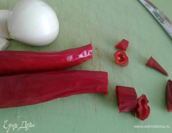 Перец чили нарежем колечками и вместе с семенами добавим к овощам. Туда же отправим чеснок, пропущенный через пресс.