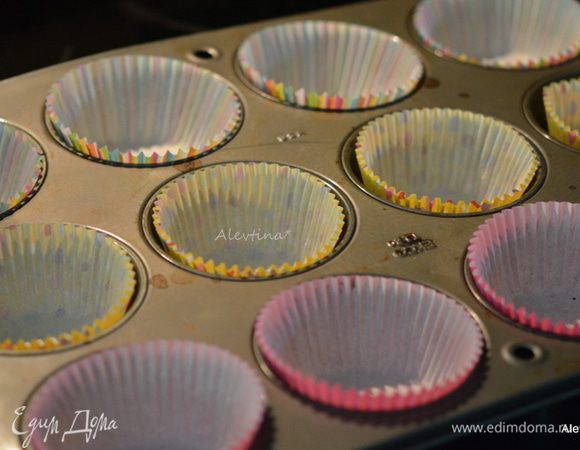 Заполнить кексовые  формы бумажными формочками.