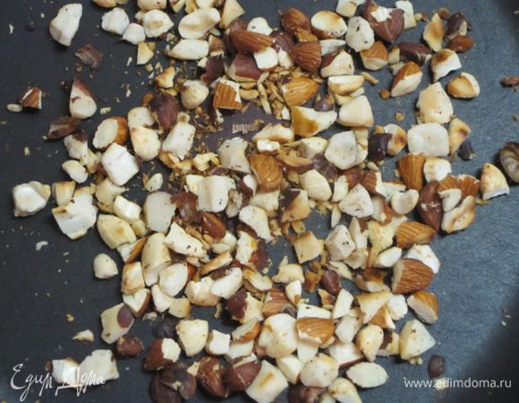 Крупные орехи разрезать пополам. Обжарить орехи на сухой сковороде. Отложить часть орехов для украшения.
