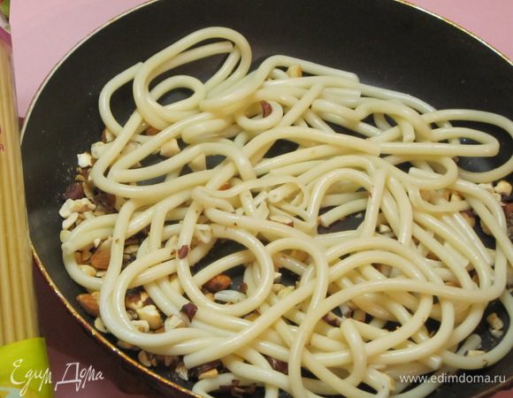 Пасту откинуть на дуршлаг,  выложить на сковороду с орехами.