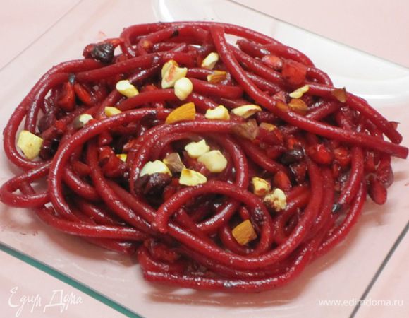 Выложить на тарелку, посыпать отложенными орехами, миндальными лепестками.