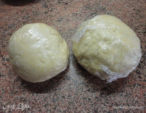 Влить кефир или простоквашу и замесить тесто. Долго не вымешивать, чтобы оно не нагрелось от рук. Разделить на две неравные часть, обернуть пищевой пленкой и отправить в холодильник на 30 минут.